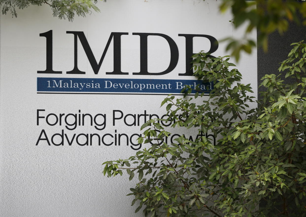 Foliage partly covers a 1 Malaysia Development Berhad (1MDB) billboard at the funds flagship Tun Razak Exchange development in Kuala Lumpur, Malaysia, July 3, 2015. Malaysian Prime Minister Najib Razak slammed a report that said close to $700 million was wired to his personal account from banks, government agencies and companies linked to the debt-laden state fund 1MDB, claiming this was a "continuation of political sabotage." REUTERS/Olivia Harris  