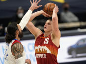 Denver Nuggets center Nikola Jokic, right, shoots over New Orleans Pelicans center Steven Adams in the first half of an NBA basketball game Wednesday, April 28, 2021, in Denver. (AP Photo/David Zalubowski)