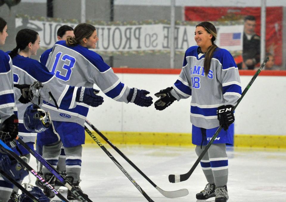 Braintree's Nikki McNamee is congratulated by teammate Callie Burchill, left, after she was honored for entering the Marine Corps during a game against Wellesley at the Zapustas Arena in Randolph, Wednesday, Jan. 31, 2024.