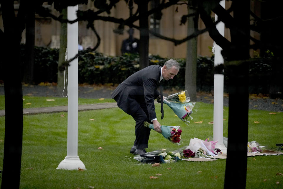 Conservative Party Member of Parliament Nigel Evans places flowers down for MP David Amess within the grounds of the Houses of Parliament in London, Monday, Oct. 18, 2021. British Prime Minister Boris Johnson will lead a special session of tributes in Parliament on Monday to the Conservative lawmaker stabbed to death as he met constituents, an attack that has fueled concern about politicians' safety and the level of vitriol directed at them. (AP Photo/Matt Dunham)