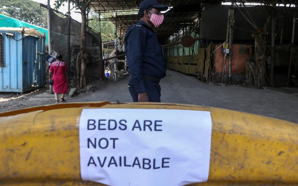 A security official outside a Covid treatment centre in Mumbai, which is full of sick people - Shutterstock 