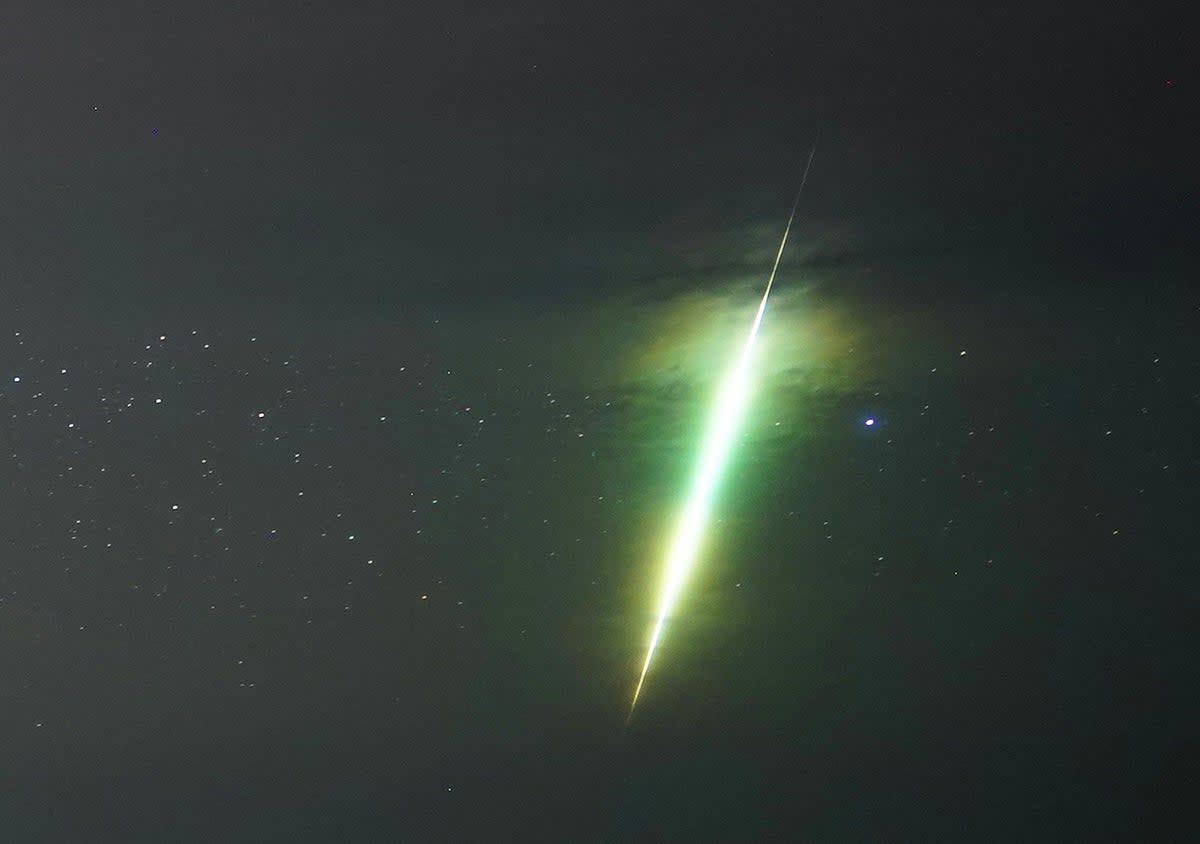 A fisherman watches a meteor during the Draconid meteor shower over Howick rocks in Northumberland  (Owen Humphreys / PA Wire)