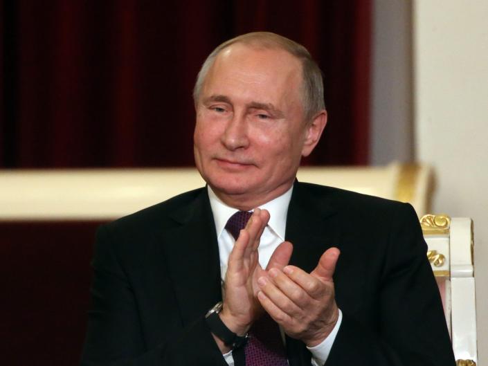 Le président russe Vladimir Poutine applaudit.