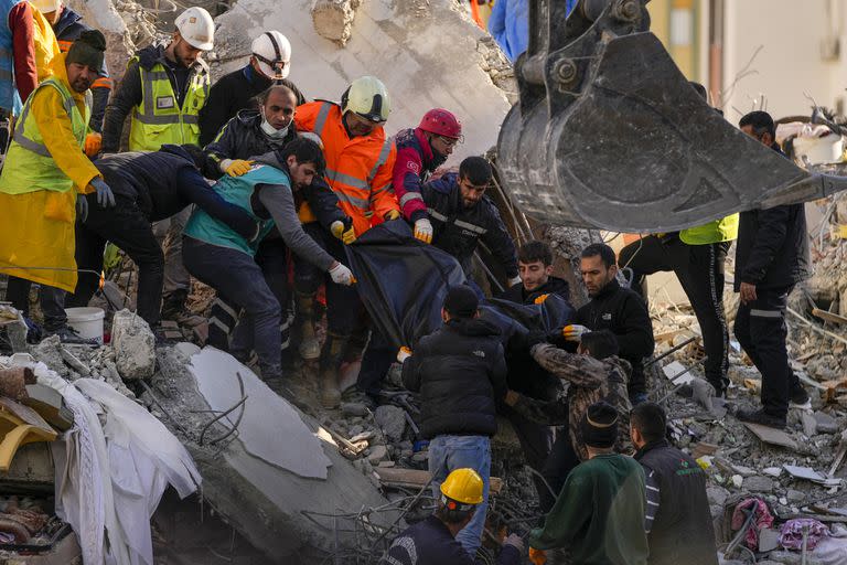 Miembros de un equipo de emergencia transportan el cuerpo de una persona hallada entre los escombros de un edificio destruido en Adana, Turquía, el martes 7 de febrero de 2023. Los equipos de rescate se apresuraron el martes a encontrar supervivientes entre los escombros de miles de edificios derribados por un fuerte terremoto y múltiples réplicas que sacudieron el este de Turquía y la vecina Siria. (AP Photo/Francisco Seco)