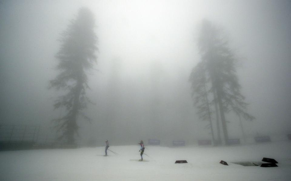 Athletes train as fog enshrouds the course of the men's biathlon 15k mass-start, at the 2014 Winter Olympics, Monday, Feb. 17, 2014, in Krasnaya Polyana, Russia. The race has been delayed due to fog, one day after the event was called off for the same reason. (AP Photo/Lee Jin-man)