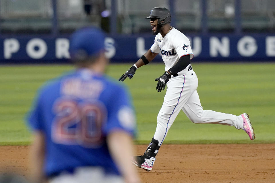 Miami Marlins' Bryan De La Cruz , right,runs the bases after hitting a grand slam off Chicago Cubs starting pitcher Wade Miley (20) during the third inning of a baseball game Monday, Sept. 19, 2022, in Miami. (AP Photo/Lynne Sladky)