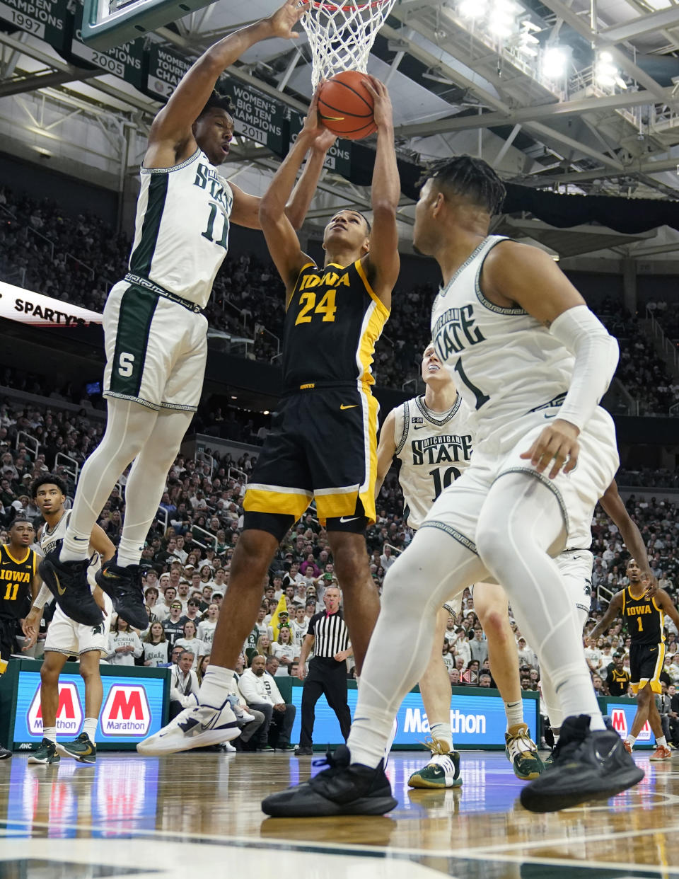 Iowa forward Kris Murray (24) attempts a layup as Michigan State guard A.J. Hoggard (11) defends during the first half of an NCAA college basketball game, Thursday, Jan. 26, 2023, in East Lansing, Mich. (AP Photo/Carlos Osorio)