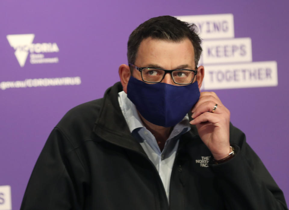 Victorian Premier Daniel Andrews arrives in a face mask to speak to the media during a press conference in Melbourne.