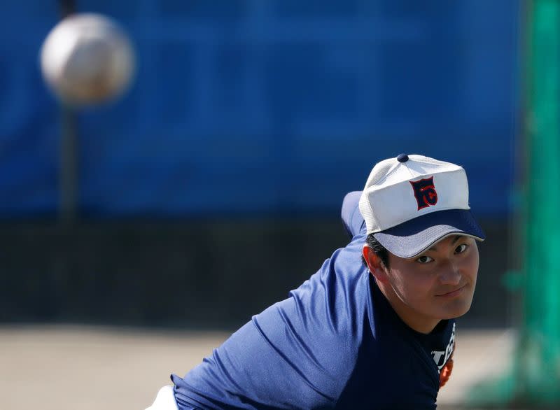 Ryoma Ouchi, an ace pitcher at Fukushima Commercial High School baseball team from Iitate, takes part in a workout at the baseball field of the school in Fukushima, Japan