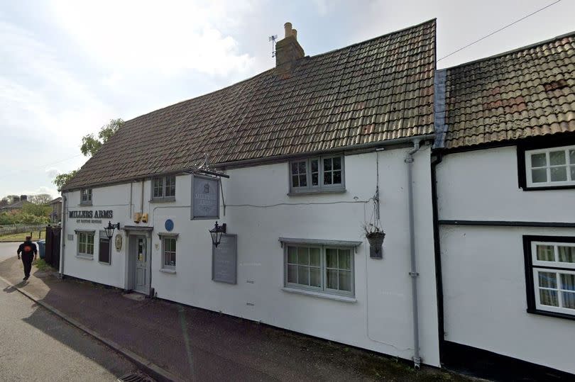 Exterior of two-storey pub, with white painted walls.