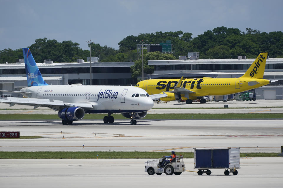FILE - A JetBlue Airways Airbus A320, left, passes a Spirit Airlines Airbus A320 as it taxis on the runway, July 7, 2022, at the Fort Lauderdale-Hollywood International Airport in Fort Lauderdale, Fla. Lawyers for the Justice Department and JetBlue Airways are scheduled to make closing arguments Tuesday, Dec. 5, 2023, to wrap up a trial that will decide whether JetBlue can buy Spirit Airlines, the nation’s biggest low-fare carrier. (AP Photo/Wilfredo Lee, File)