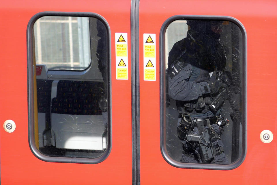 Armed police officers walk through the carriage of of the Tube train.