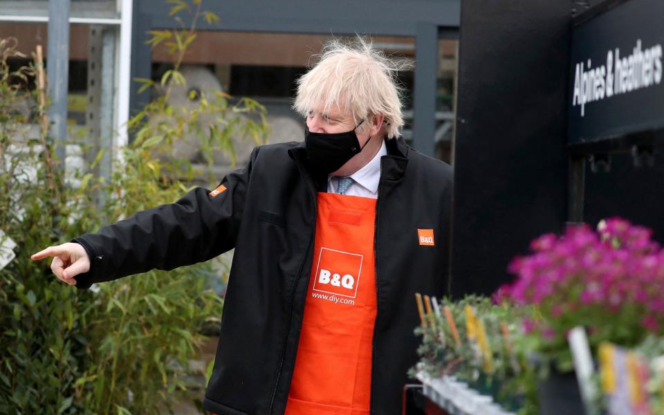 Britain's Prime Minister Boris Johnson gestures as he visits the garden centre of a DIY shop in Middlesbrough - SCOTT HEPPELL