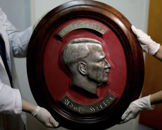 Members of the federal police show a bust relief portrait of Nazi leader Adolf Hitler at the Interpol headquarters in Buenos Aires. Source: AP Photo/Natacha Pisarenko