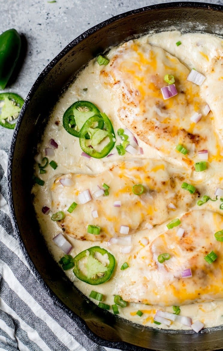 A skillet of chicken in cheesy jalapeño cream sauce