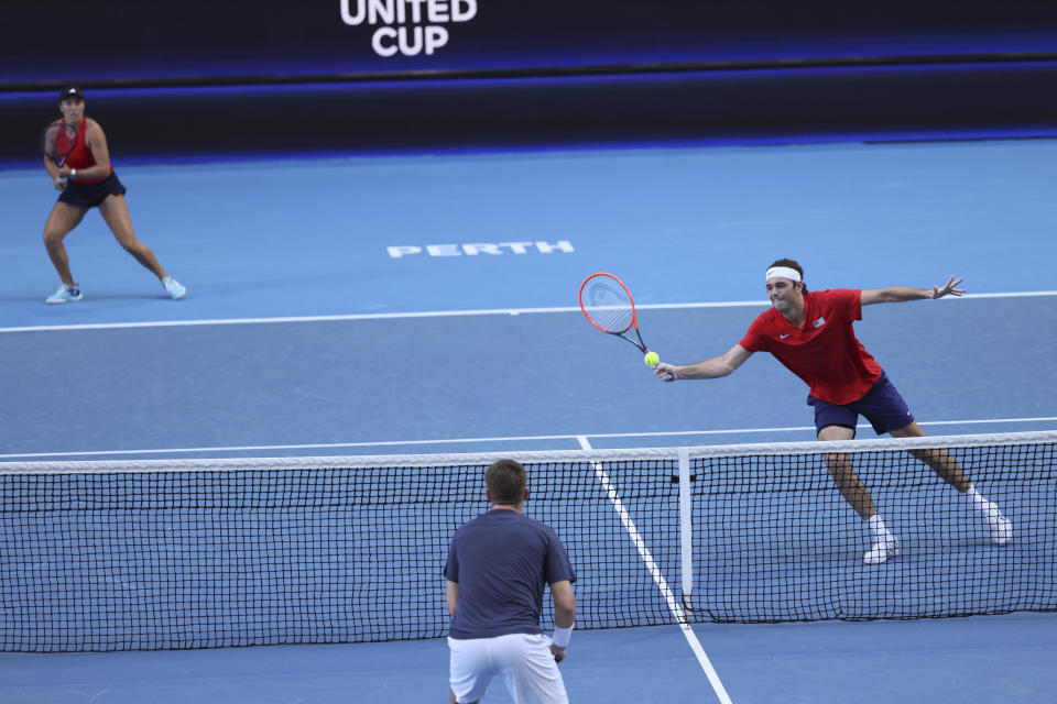 Taylor Fritz of the United States hits a shot at the net as partner Jessica Pegula looks on during their mixed doubles match against Cameron Norrie and Katie Boulter of Britain at the United Cup tennis tournament in Perth, Australia, Sunday, Dec. 31, 2023. (AP Photo/Trevor Collens)