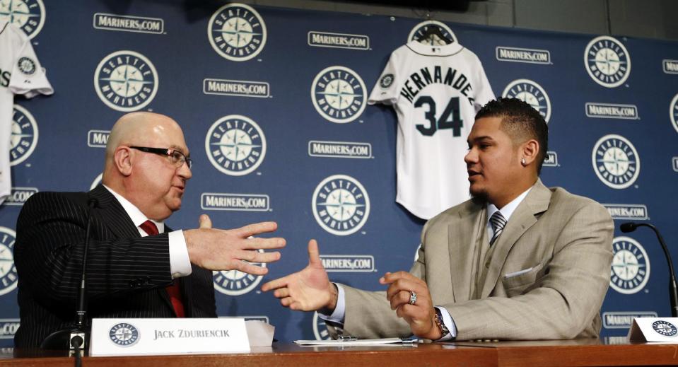 Seattle Mariners' Felix Hernandez, right, shakes hands with general manager Jack Zduriencik after signing a agreement in his new contract to start a news conference, Wednesday, Feb. 13, 2013, in Seattle. Hernandez signed a seven-year contract with the Mariners that makes him the highest-paid pitcher in baseball. The new deal will be worth $175 million. (AP Photo/Elaine Thompson)