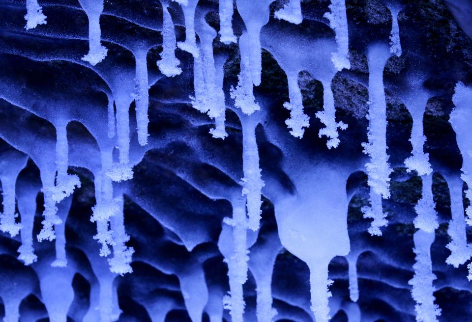 In this Feb. 2, 2014 photo, people visit the caves at Apostle Islands National Lakeshore in northern Wisconsin, transformed into a dazzling display of ice sculptures by the arctic siege gripping the Upper Midwest. The caves are usually accessible only by water, but Lake Superior’s rock-solid ice cover is letting people walk to them for the first time since 2009. (AP Photo/Minneapolis Star Tribune, Brian Peterson)