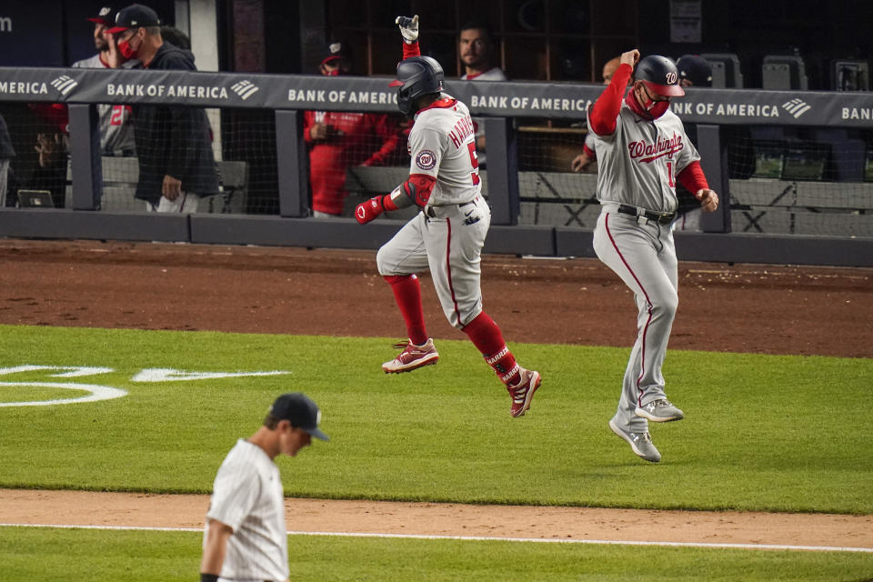Washington Nationals' Josh Harrison (5) celebrates with third base coach Bob Henley after hitting a three-run home run during the eighth inning of the team's baseball game against the New York Yankees on Friday, May 7, 2021, in New York. (AP Photo/Frank Franklin II)