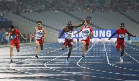 Qatar's Femi Seun Ogunode (C) crosses the finish line in the men's 100m final at the Incheon Asiad Main Stadium during the 17th Asian Games September 28, 2014. REUTERS/Kim Kyung-Hoon