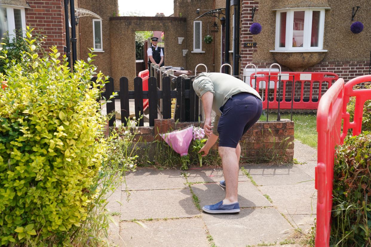 A man lays flowers at the scene in Bedfont (Lucy North/PA Wire)