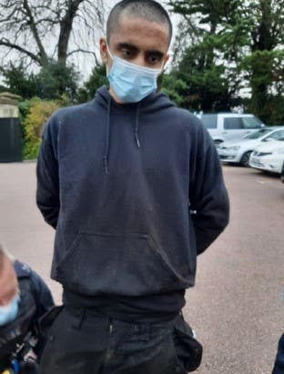 Jaswant Singh Chail in navy hoodie and blue medical mask with police officer bending down