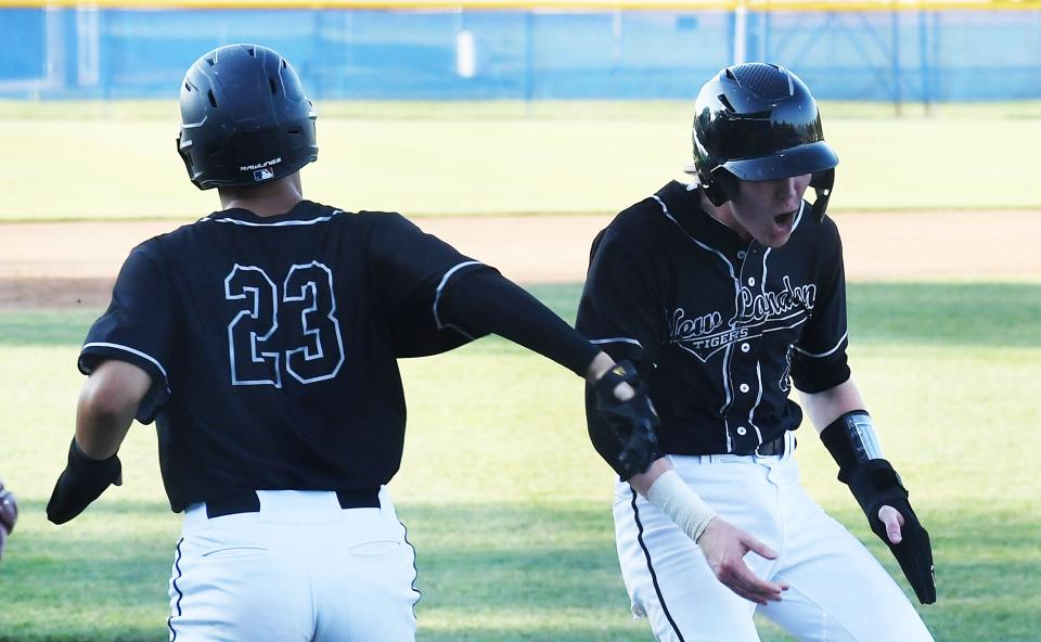 New London's Tucker Gibbar (10) and Dereck Santiago (23) celebrate after two runs scored against Newman Catholic during the first inning in the Class 1A baseball semi-final at Merchants Park, July 20, 2022, in Carroll, Iowa.