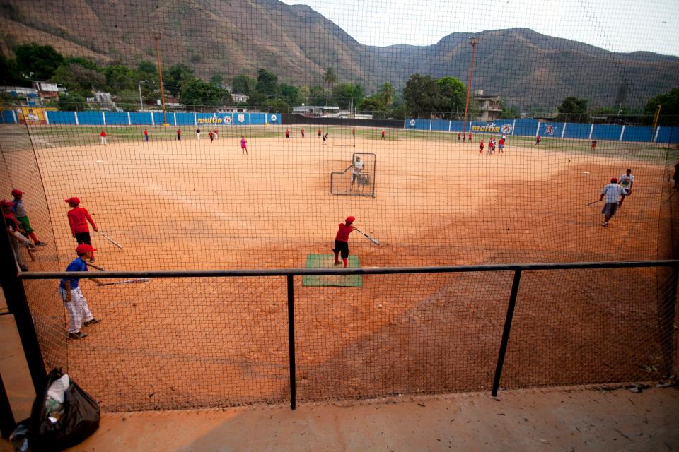 Boys attend a fielding and batting practice on the same field Detroit Tiger's Miguel Cabrera learned to play, in Maracay, Venezuela, Friday, March 28, 2014. Cabrera’s parents moved to a more affluent Maracay neighborhood after their son received a $1.8 million signing bonus from the Florida Marlins in 1999 at the age of 16. But the rest of his sprawling family continues live in the narrow streets and sun-bleached buildings of this community at the foot of a mountain an hour and a half west of Caracas. (AP Photo/Alejandro Cegarra)