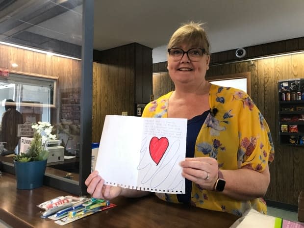 Annette Mason holds up the card that the Hope sisters made for the staff of the Snowshoe Inn. 