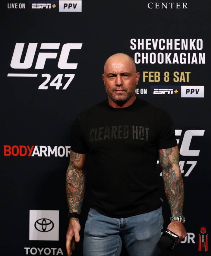 Rogan stands at a step-and-repeat