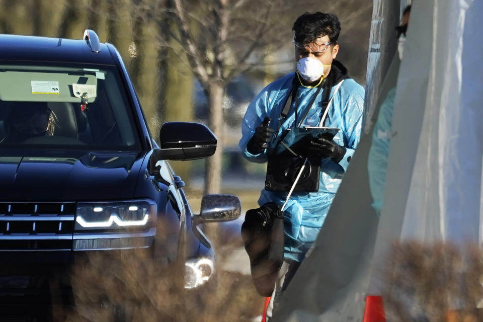 A health worker of Rocket Testing, conducts a test at the COVID-19 testing site at the Hawthorn Mall parking lot in Vernon Hills, Ill., Thursday, Jan. 21, 2021. A new drive-up rapid COVID-19 testing facility has opened in Vernon Hills. Rocket Testing, which currently has seven locations in the Chicago area. No appointment is necessary, and test can remain in the car while people wait, according to the Rocket Testing Facebook page. The test takes just minutes, and results are typically available in 15 minutes. (AP Photo/Nam Y. Huh)