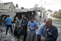 Palestinians wait in front of the rubble of a destroyed house after Israeli security forces demolished the homes of two Palestinians behind attacks in the Palestinian neighborhood of Jabal Mukaber in east Jerusalem, on October 6, 2015