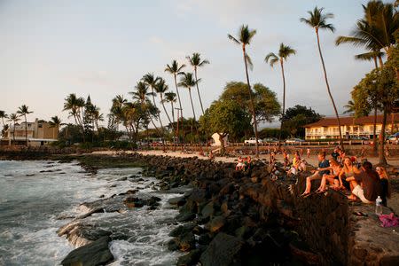 Tourists and locals watch the sunset from White Sands Beach Park in Kailua-Kona, on Hawaii's Big Island, January 31, 2016. REUTERS/Canice Leung