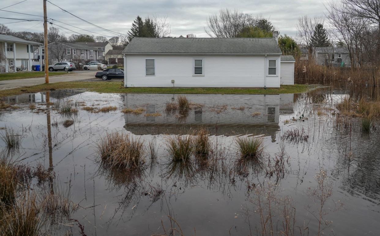 A cottage in the Luther's Corner neighborhood of East Providence appears to be sitting in the middle of a pond the morning after last Tuesday’s heavy rains.