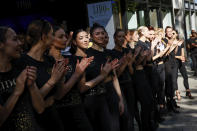 Lido cabaret dancers applaud during a demonstration outside the cabaret as dancers, other employees and union activists are gathering to try to save their jobs and the history of the cabaret, known for its dinner theater and its "Bluebell Girls" revue, Saturday, May 28, 2022 in Paris. Amid financial troubles and changing times, the venue's new corporate owner is ditching most of the Lido's staff and its high-kicking, high-glamour dance shows — which date back decades and inspired copycats from Las Vegas to Beirut — in favor of more modest musical revues. (AP Photo/Thomas Padilla)