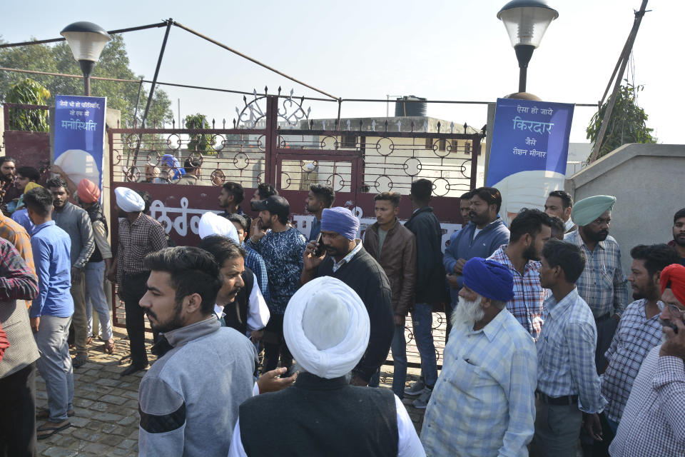 People gather outside after a blast at Nirankari Bhawan, a prayer hall in Adliwal village near Amritsar, India, Sunday, Nov.18, 2018. Three people were killed and over a dozen injured on Sunday when two men on a motorbike targeted the prayer hall with a grenade police said. (AP Photo/Prabhjot Gill)