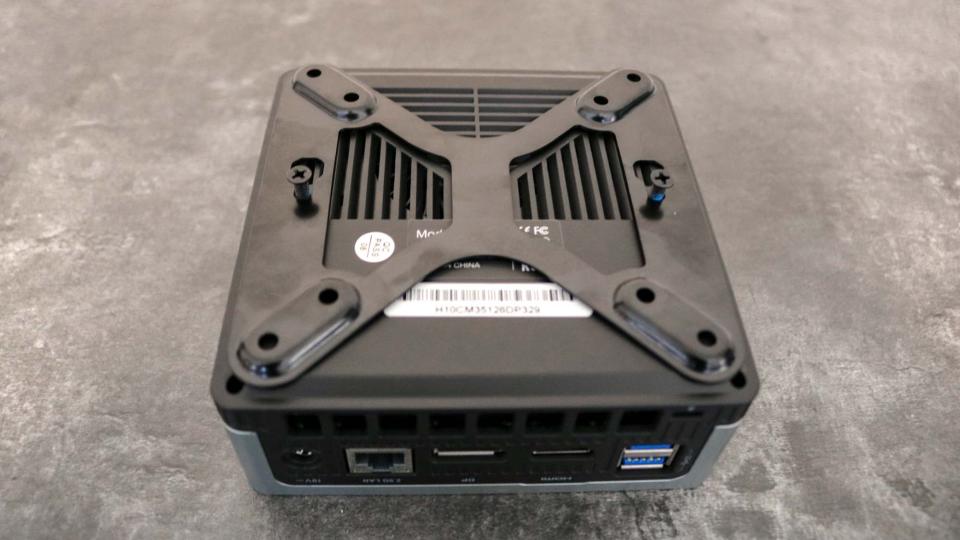 A mini PC with a VESA bracket mounted on the bottom