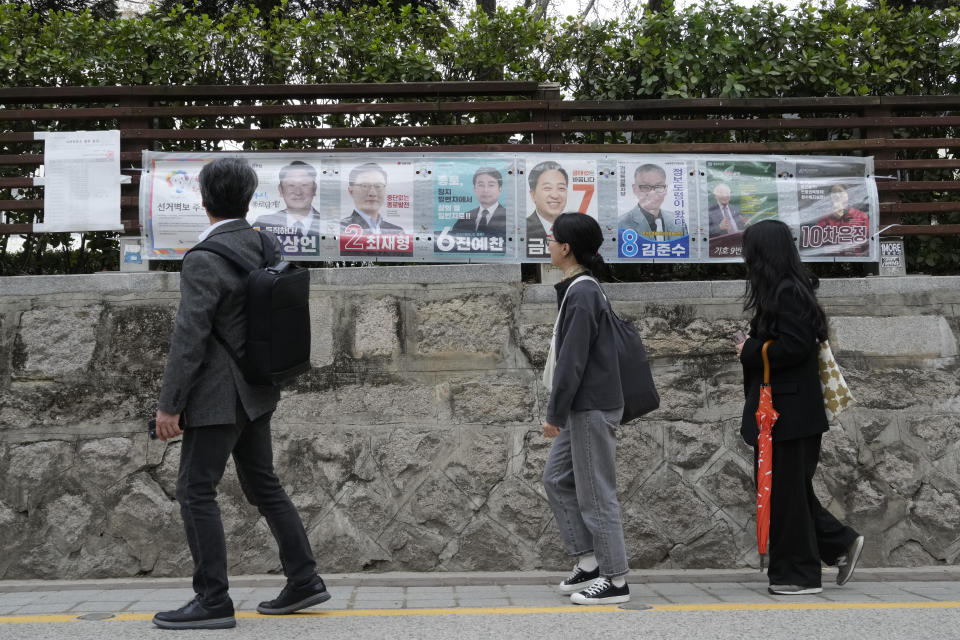 People pass by posters of candidates running for the upcoming parliamentary election in Seoul, South Korea, Wednesday, April 3, 2024. As South Koreans prepare to vote for a new 300-member parliament next week, many are choosing their livelihoods and other domestic topics as their most important election issues. This represents a stark contrast from past elections, which were overshadowed by security and foreign policy issues like North Korean nuclear threats and the U.S. security commitment.(AP Photo/Ahn Young-joon)