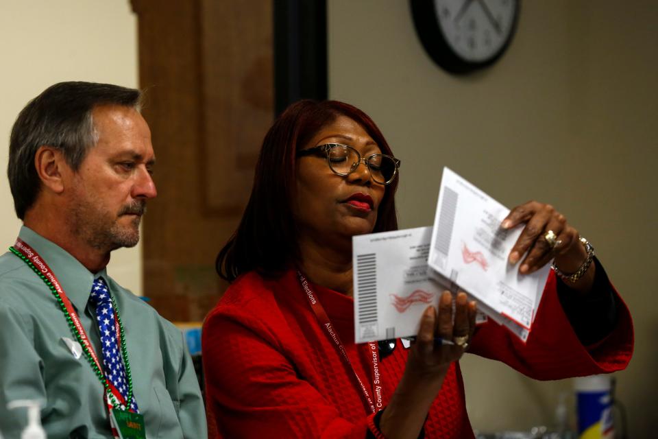 Kim Barton, the Alachua County Supervisor of Elections, and Thomas Jaworski look at ballots at the Supervisor of Elections Office in Gainesville, Fla. on March 17, 2020.