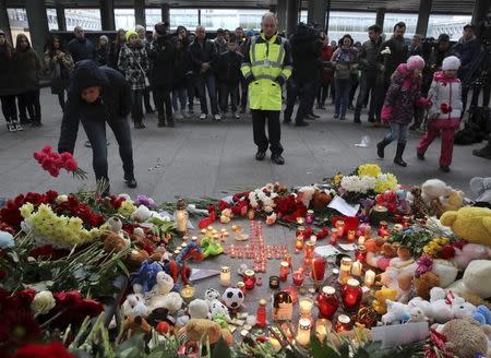 People lay flowers on a makeshift memorial for victims of a Russian airliner which crashed in Egypt, outside Pulkovo airport in St. Petersburg, Russia November 1, 2015. Airbus A321, operated by Russian airline Kogalymavia under the brand name Metrojet, carrying 224 passengers crashed into a mountainous area of Egypt's Sinai peninsula on Saturday shortly after losing radar contact near cruising altitude, killing all aboard. Russian President Vladimir Putin declared a day of national mourning for Sunday. REUTERS/Peter Kovalev