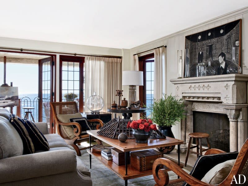 In the ground-floor sitting room of his <a rel="nofollow noopener" href="https://www.architecturaldigest.com/story/lee-stanton-antiques-collecting-laguna-beach-home-article?mbid=synd_yahoo_rss" target="_blank" data-ylk="slk:California home;elm:context_link;itc:0;sec:content-canvas" class="link ">California home</a>, antiques dealer Lee Stanton arranged a vintage French cocktail table, a pair of circa-1840 lounge chairs, and a sofa of his own design in front of a stone mantel from an English country estate; the walls are painted in Benjamin Moore’s Linen Sand.