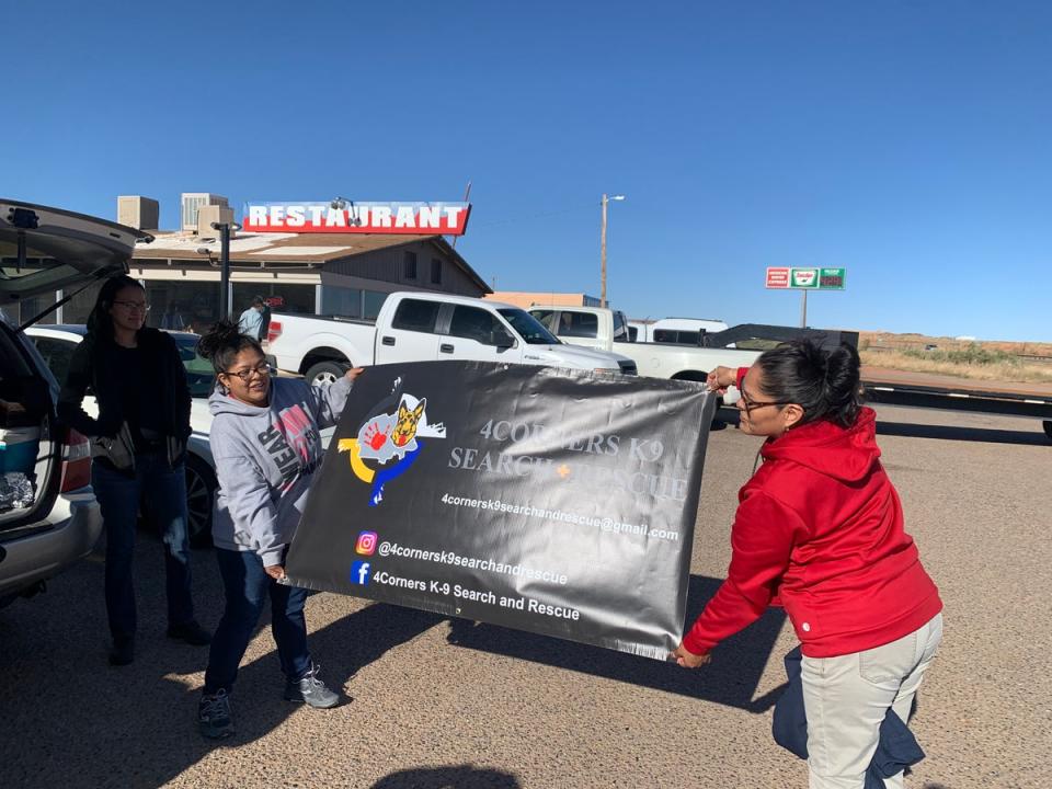 Volunteers with Four Corners K9 Search and Rescue unfurl a new banner before a search for a missing person on the Navajo Nation on April 23rd, 2022. (Justin Higginbottom)