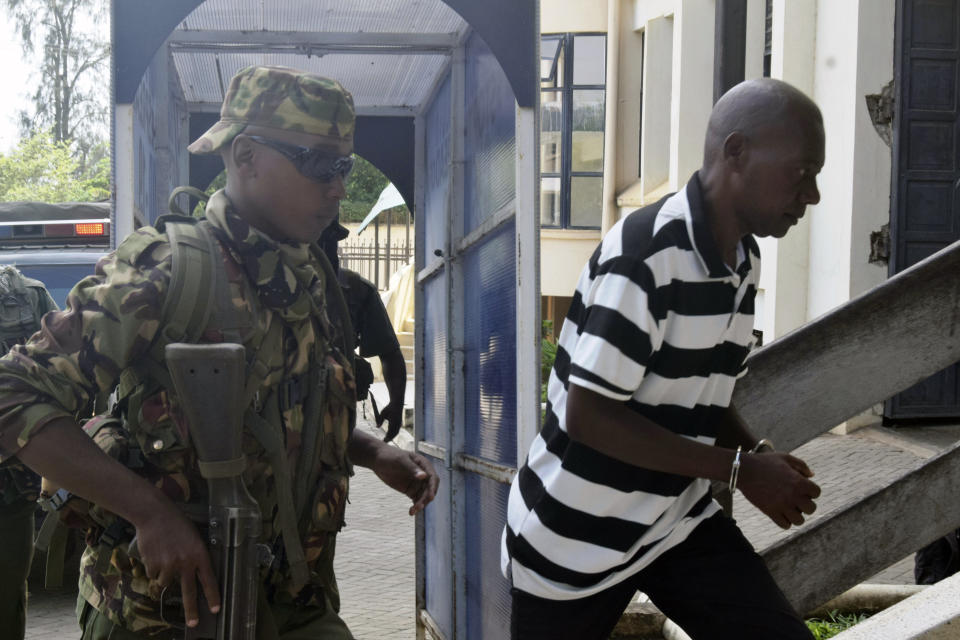 Cult preacher Pastor Paul Nthenge Mackenzie, right, arrives at the Malindi Law Courts under tight security, Friday Dec. 1, 2023 for the sentencing of his 2019 case where he had been charged with three counts of being in possession of films intended to incite children against attending school and incite Christians, Hindus, Buddhists and Islams on their religion. In the second count, he was found guilty of being on procession and distributing films to the public which had not been examined and classified by Kenya Films Classifications Board. The third charge stated that he was found operating a films studio and producing films for public consumption without first registering as a film agent and acquiring a filming license. He was jailed for eighteen months imprisonment for the three counts. (AP Photo/Gideon Maundu).