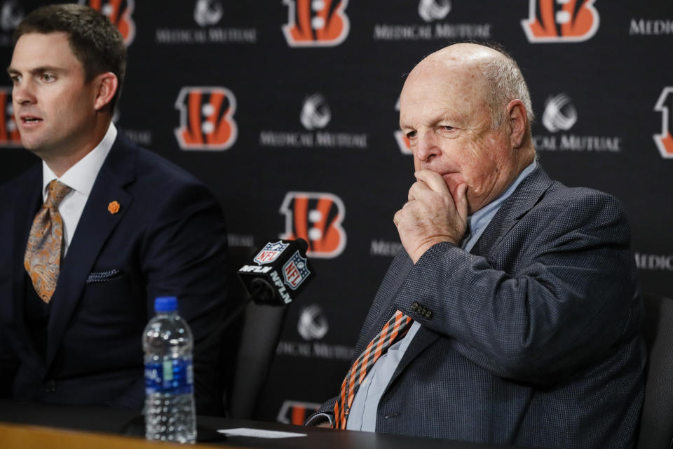 Cincinnati Bengals owner Mike Brown, right, listens as the new head coach Zac Taylor, left, answers reporter's questions during a news conference, Tuesday, Feb. 5, 2019, in Cincinnati. After 16 years without a playoff win under Marvin Lewis, the Bengals decided to try something different. But they had to wait more than a month before hiring Zac Taylor as their next coach in hopes of ending a long streak of futility. (AP Photo/John Minchillo)