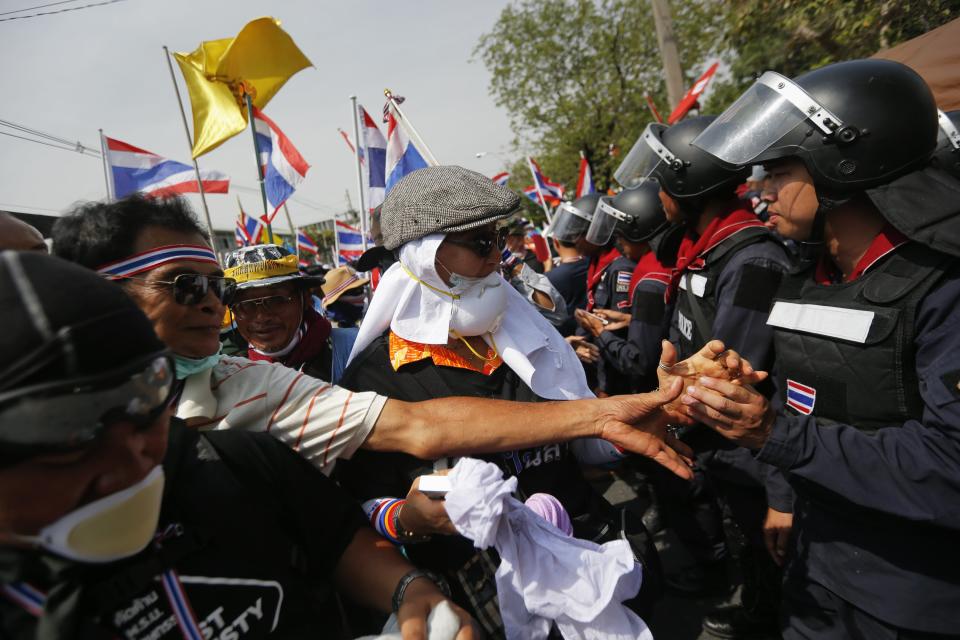 Policemen and anti-government protesters greet each other inside the compound of the metropolitan police headquarters, the site of fierce clashes over the last few days, in Bangkok December 3, 2013. Thailand's government ordered police to stand down and allow protesters into state buildings on Tuesday, removing a flashpoint for clashes and effectively bringing an end to days of violence in Bangkok in which five people have died. REUTERS/Damir Sagolj