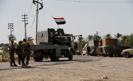 Shi'ite fighters stand with their weapons on the outskirts of Saqlawiya north of Falluja, Iraq, June 2, 2016. REUTERS/Thaier Al-Sudani