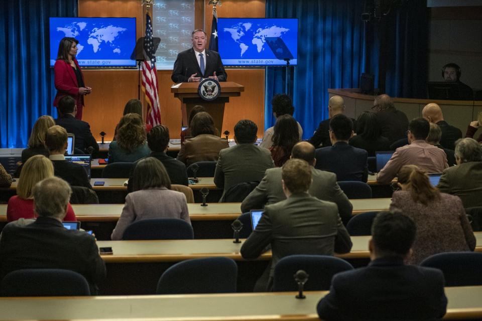 Pompeo, standing at the podium, speaks to seated reporters in the White House Press Briefing Room