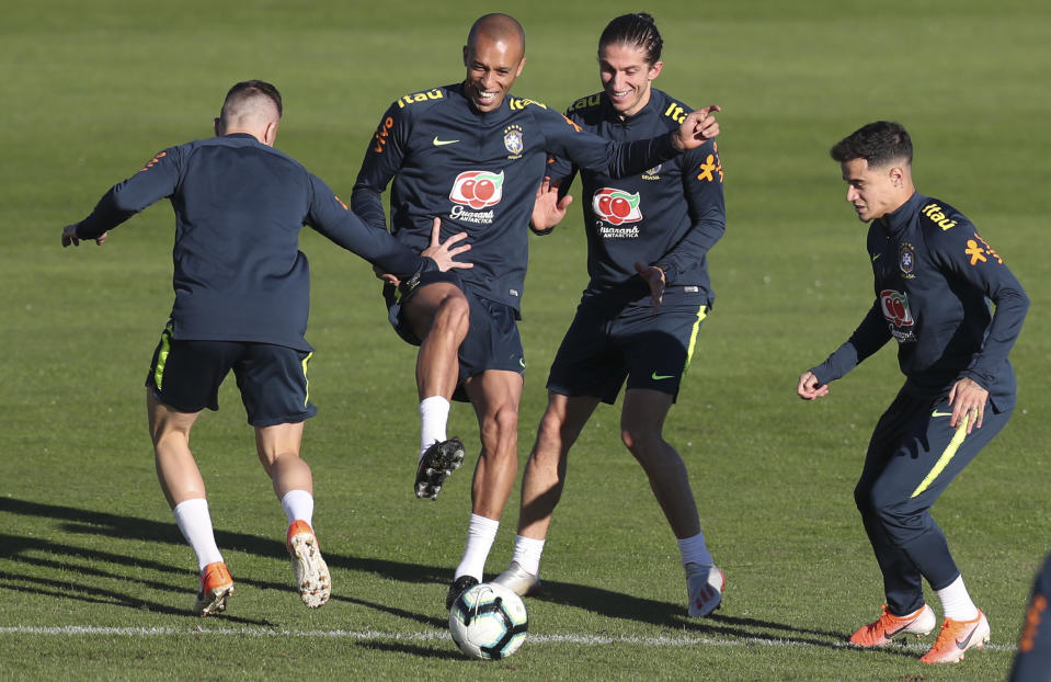 Arthur, Miranda, Filipe Luis and Phlippe Coutinho, from left to right, play with a ball during a training session of Brazil national soccer team in Porto Alegre, Brazil, Wednesday, June 26, 2019. Brazil will play against Paraguay for a Copa America quarter-final match on June 27.(AP Photo/Natacha Pisarenko)