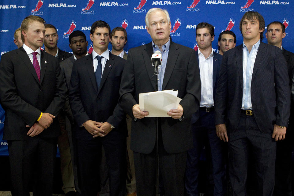 FILE - In this Aug. 14, 2012, file photo, Donald Fehr, center, executive director of the National Hockey League Players' Association, stands with NHL hockey players including Tampa Bay Lightning's Steven Stamkos, left, Pittsburgh Penguins' Sidney Crosby, second from left, and Washington Capitals' Alex Ovechkin, right, as they speak with reporters following collective bargaining talks in Toronto. The NHLPA announces its decision whether to terminate the current collective bargaining agreement and set the clock ticking toward another potential work stoppage in 2020. (AP Photo/The Canadian Press, Chris Young, File)