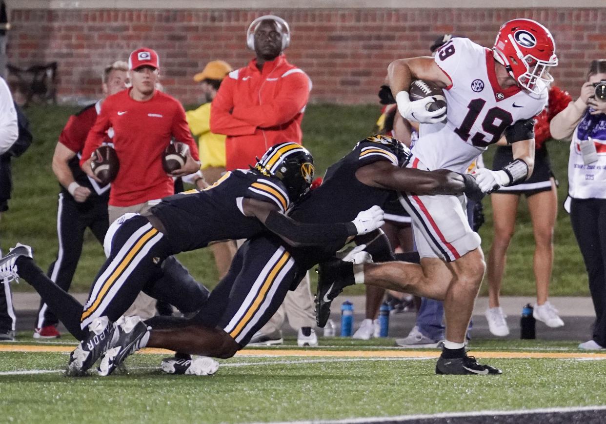 Oct 1, 2022; Columbia, Missouri, USA; Georgia Bulldogs tight end Brock Bowers (19) runs as Missouri Tigers defensive back Jaylon Carlies (1) and defensive back Ennis Rakestraw Jr. (2) attempt a tackle during the second half at Faurot Field at Memorial Stadium. Mandatory Credit: Denny Medley-USA TODAY Sports